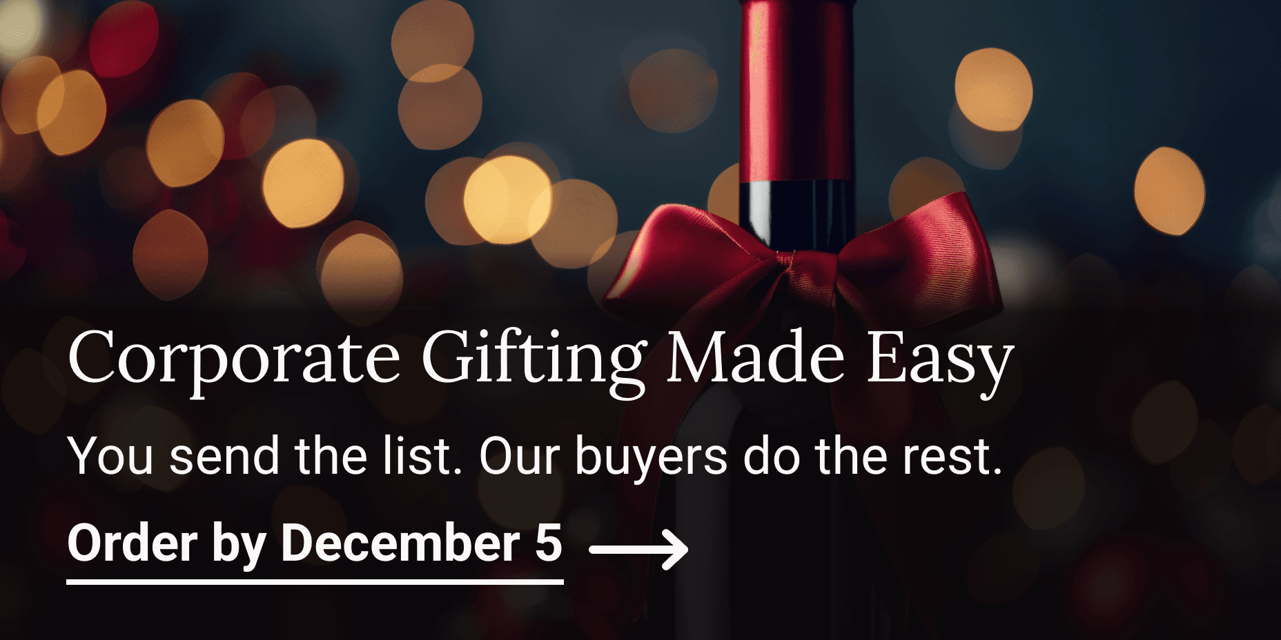 Corporate and Holiday Gifting is available at K&L. Wine bottle with a red bow and blurred lights in the background.